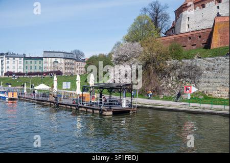 Cracovie, Pologne – 12 avril 2026 : Les visiteurs profitent du soleil près de la rive à Cracovie, en Pologne, tout en se promenant et en se reposant. Banque D'Images