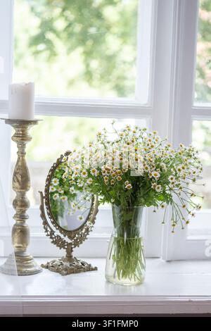 Une composition de nature morte délicate et romantique mettant en scène un bouquet de marguerites fraîches blanches en camomille dans un vase en verre, Banque D'Images