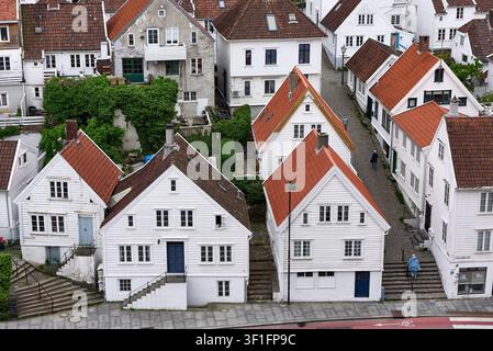 Vue en contre-plongée de maisons traditionnelles en bois blanc du XVIIIe siècle avec des toits de tuiles rouges le long des marches pavées de Bergsmauet à Gamle Stavanger, en Norvège Banque D'Images