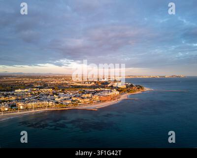 Vue aérienne de la ville côtière et de la plage de sable à l'heure dorée sur une mer bleue calme, Cambrils, Espagne Banque D'Images