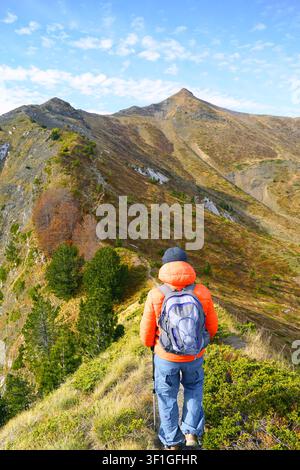 Randonneur solitaire avec sac à dos se tient sur une crête étroite entre les sommets Volusnica et Talijanka. Montre la voie de connexion des sommets et la navigation des sentiers panoramiques. Banque D'Images