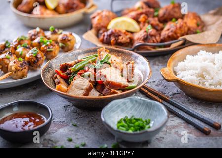 Délicieux festin asiatique avec un ventre de porc croustillant, des ailes de poulet et du riz Banque D'Images