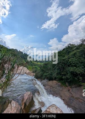 Vue à couper le souffle depuis le sommet d'une cascade surplombant une vallée verdoyante Banque D'Images