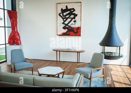 Un salon moderne avec de l'art abstrait et des meubles de milieu de siècle. Banque D'Images
