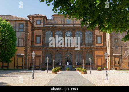 Grand plan de la cour historique et de la façade majestueuse de la Villa Mondragone en Italie, présentant une allée pavée et des topiaires vertes soigneusement taillées Banque D'Images