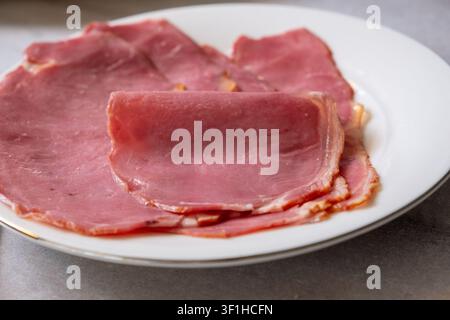 Close-up de tranches de viande séchée servies sur une assiette en céramique blanche Banque D'Images