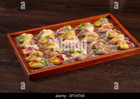 Dumplings de légumes colorés crus et frais sur des assiettes, Jiaozi chinois congelés Banque D'Images