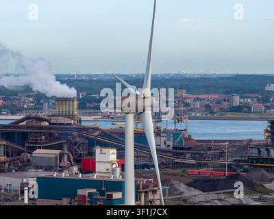 Velsen-Noord, Pays-Bas – 06 juillet 2026 : Vue aérienne d’une éolienne dans le complexe industriel de Tata Steel avec des cheminées fumantes, infrastructure industrielle Banque D'Images