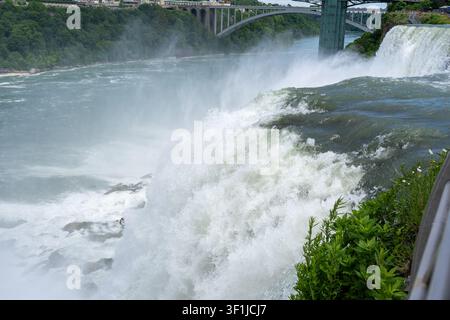 Un plan horizontal en gros plan se concentrant sur l'eau blanche puissante et rugissante ainsi que sur l'écume épaisse au sommet des chutes du Niagara. Une épaisse brume et des gouttelettes d'eau s'élèvent Banque D'Images