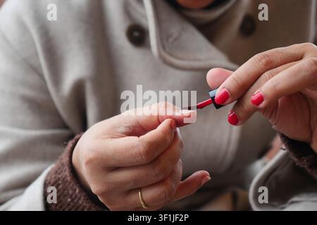Femme se maquille les ongles à la maison en après-midi Banque D'Images