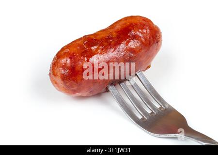 Saucisse de viande frite sur fond blanc. Saucisse sur une fourchette. Saucisse fraîche faite maison. Banque D'Images