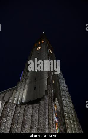Tour en béton illuminée de Hallgrimskirkja contre le ciel nocturne noir de Reykjavik Banque D'Images
