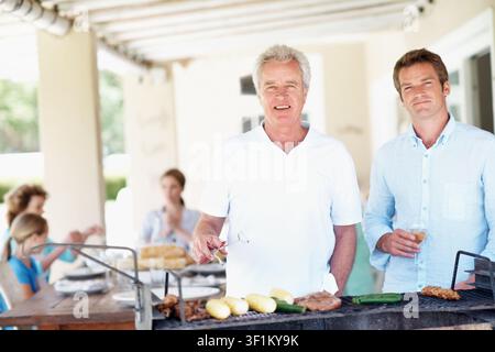 Barbecue, portrait et père âgé avec homme à la maison pour cuisiner, sourire et célébration familiale. Réunion Bbq, vacances d'été et grill avec des gens en Banque D'Images