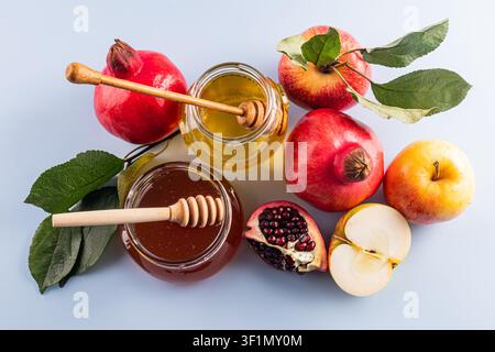 Une exposition vibrante des symboles traditionnels de Rosh Hashanah, mettant en vedette des pots de miel, des pommes fraîches et des grenades. Idéal pour célébrer avec des douceurs et Banque D'Images