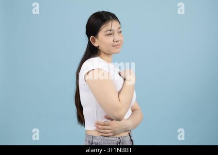 Jeune femme gracieuse se retournant et regardant par-dessus son épaule dans le studio Banque D'Images