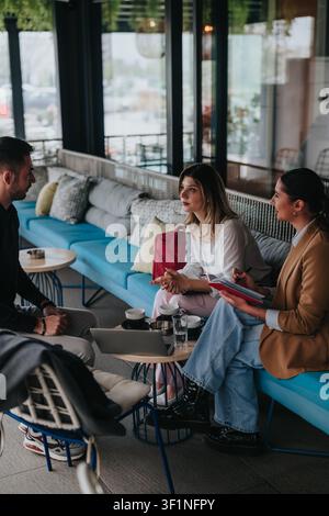 Des collègues ayant une réunion de travail à distance et une discussion dans un salon de café détendu Banque D'Images