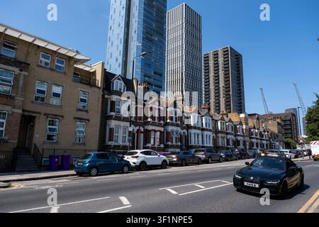 Un nouveau bloc d'appartements en hauteur domine une ancienne rangée de maisons basses au cœur du quartier financier de Canary Wharf le 13 juillet 2026 à Londres, Royaume-Uni. Canary Wharf est une zone située près de l'Isle of Dogs dans le borough londonien de Tower Hamlets et est définie par la Greater London Authority comme faisant partie du quartier central des affaires de Londres. Avec la City de Londres, elle constitue l'un des principaux centres financiers du Royaume-Uni et du monde, comprenant de nombreux gratte-ciel dont le troisième plus haut du Royaume-Uni, One Canada Square. Banque D'Images