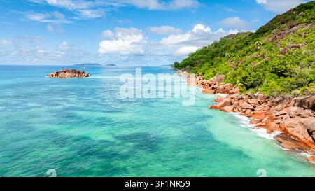 Une vue panoramique d'eaux turquoise vibrantes s'étendant vers des îles lointaines, encadrées par la rive rocheuse. Banque D'Images