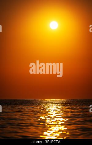 Couchant doré sur un océan calme avec reflet du soleil et espace de copie Banque D'Images