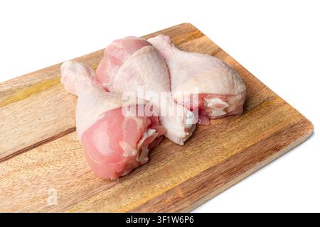 Bottes de poulet crues isolées, cuisses de volaille non cuites, viande de poulet fraîche, cuisse de poulet fraîche sur fond de planche à découper en bois Banque D'Images