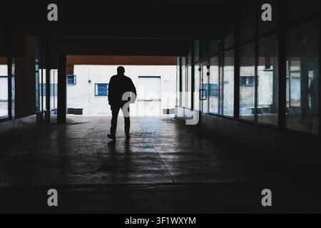 Silhouette de personne qui marche dans le corridor sombre Banque D'Images
