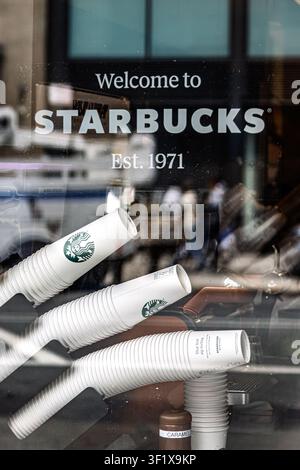 Des piles de gobelets en carton s'alignent dans une vitrine d'un café Starbucks à New York City. Banque D'Images