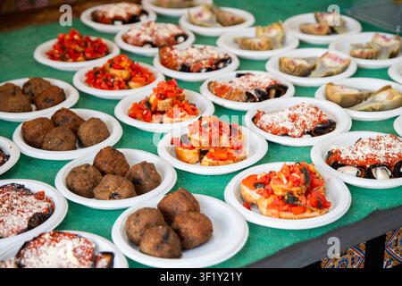 Étal de street food du marché Ballaro à Palerme avec vin et divers plats de rue siciliens. Banque D'Images