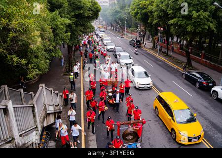 Taipei, Taïwan, 27 juin 2026 : Un plan large à angle élevé capture la procession de Linganshe avançant pendant la parade d'anniversaire du dieu de la ville de Xiahai Banque D'Images