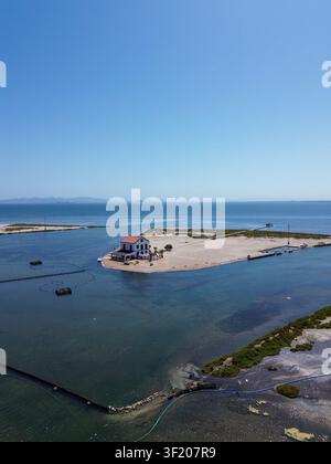 Vue aérienne des golas del mar menor montrant une maison blanche traditionnelle située sur une bande de terre côtière pittoresque entourée d'une eau bleue calme Banque D'Images