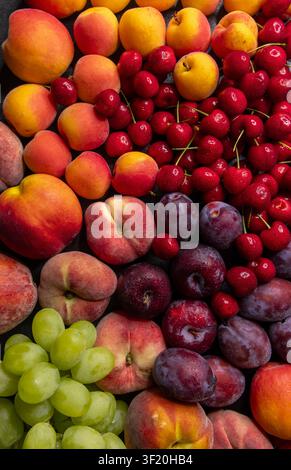 Fruits à pépins frais variés et raisins verts créant un arrière-plan alimentaire vibrant et sain Banque D'Images