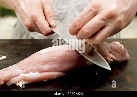 Couper un morceau de porc sur la table. Porc cru Banque D'Images