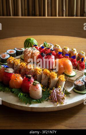 Un plateau magnifiquement disposé d'assortiments de sushi sur une table en bois, mettant en valeur une variété de couleurs et de types. Banque D'Images