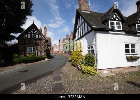 Charmants cottages en bois noir et blanc de style Tudor le long d'une ruelle pavée sinueuse par une journée ensoleillée, Great Budworth, Cheshire, Angleterre, Royaume-Uni. Banque D'Images