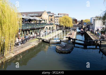 Des gens se détendant dans des bars en plein air et se promenant le long du chemin de halage du canal à Camden Lock par une journée ensoleillée, Camden Market, Londres, Angleterre, Royaume-Uni. Banque D'Images