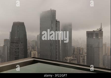 Chongqing, Chine - 8 juin 2026 - Une vue élevée à grand angle sur un groupe dense de gratte-ciel modernes perçant à travers une épaisse couche de basse altitude Banque D'Images