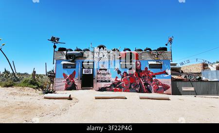 Silverton, Australie - 12 décembre 2024 : Vue du musée Mad Max 2 avec ses fresques murales emblématiques sur le thème du film et son extérieur en tôle ondulée sous un ciel dégagé Banque D'Images