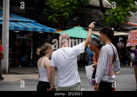 BANGKOK, THAÏLANDE - 12 JUILLET 2026 : Famille de touristes explorant le marché de Chatuchak à Bangkok, vue de dos Banque D'Images