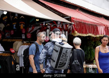 BANGKOK, THAÏLANDE - 12 JUILLET 2026 : des backpackers explorant un marché en plein air à Bangkok, vue de dos, Chatuchak. Banque D'Images