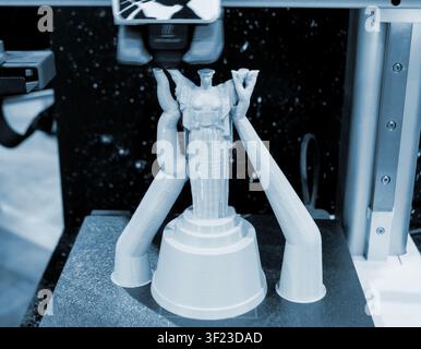 Processus d'impression 3D d'une figurine. Processus d'impression 3D d'une figurine miniature sur une imprimante FDM. Modèle en plastique PLA. Modélisation par dépôt fondu. Technologie de fabrication additive moderne. Impression 3D Banque D'Images