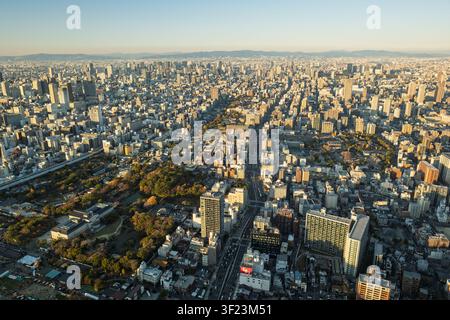 Vue large et élevée sur le vaste paysage métropolitain et la grille des rues d'Osaka s'étendant jusqu'à l'horizon lointain, Japon. Banque D'Images