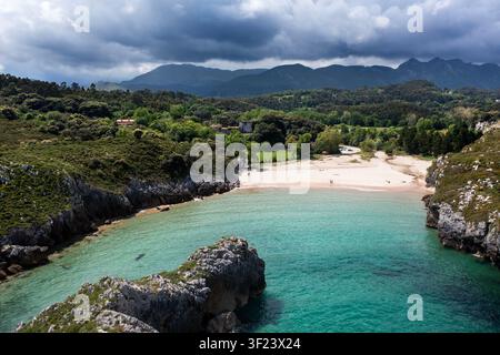 Vue aérienne de la plage de Cuevas del Mar, une plage de sable spectaculaire encadrée par des arches rocheuses naturelles et des formations de calcaire sur la côte asturienne, Asturies Banque D'Images