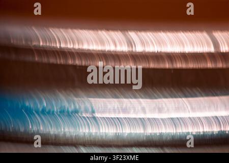 Traînées de lumière horizontales abstraites avec des tons cuivrés et cyan créant un fond de mouvement moderne. Banque D'Images