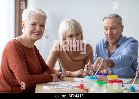 Couple âgé caucasien heureux s'adonnant à une activité artistique ensemble à la maison Banque D'Images