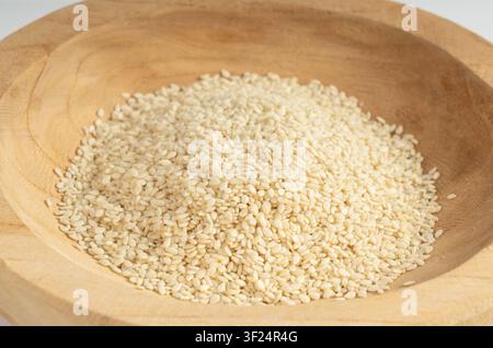 Graines de sésame dans un bol gros plan, petits grains blancs de benne, tas de fruits de Sesamum indicum gros plan Banque D'Images