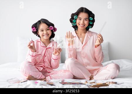 Mère et fille asiatiques heureuses s'amusant avec l'art des ongles à la maison, concept de soins de la peau Banque D'Images