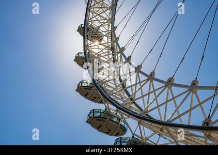 Gros plan d'un détail architectural des capsules de la roue panoramique du London Eye avec un éclatant soleil en forme d'étoile scintillant à travers les câbles d'acier, Londres Banque D'Images