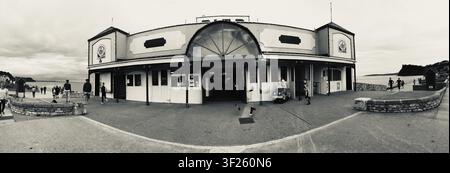 Bâtiment au bord de la mer avec un quai en arrière-plan, représenté en noir et blanc, Panorama, Paignton Pier, Devon, Royaume-Uni Banque D'Images