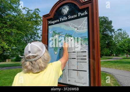 Touriste âgé désigne une carte de la région à l'intérieur du parc d'État des chutes du Niagara à New York, États-Unis Banque D'Images