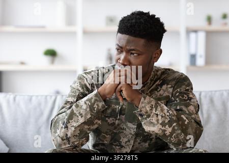 Jeune soldat afro-américain pensif réfléchissant profondément à la maison, concept de bien-être Banque D'Images