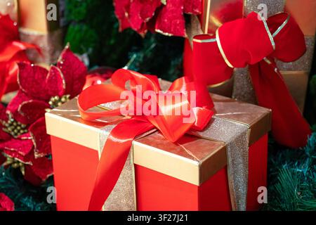 Cadeaux de Noël emballés et noués avec des rubans à côté du sapin. Gros plan. Concept de Noël et des fêtes. Banque D'Images